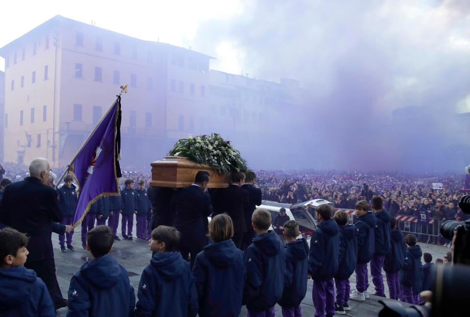 Smoke whirls around the square as the coffin leaves the Basilica