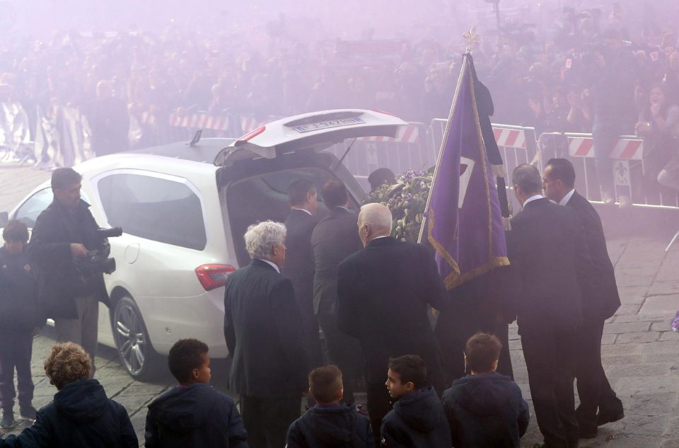 Astori's coffin is loaded into the hearse by pallbearers as the air is turned purple outside his funeral service