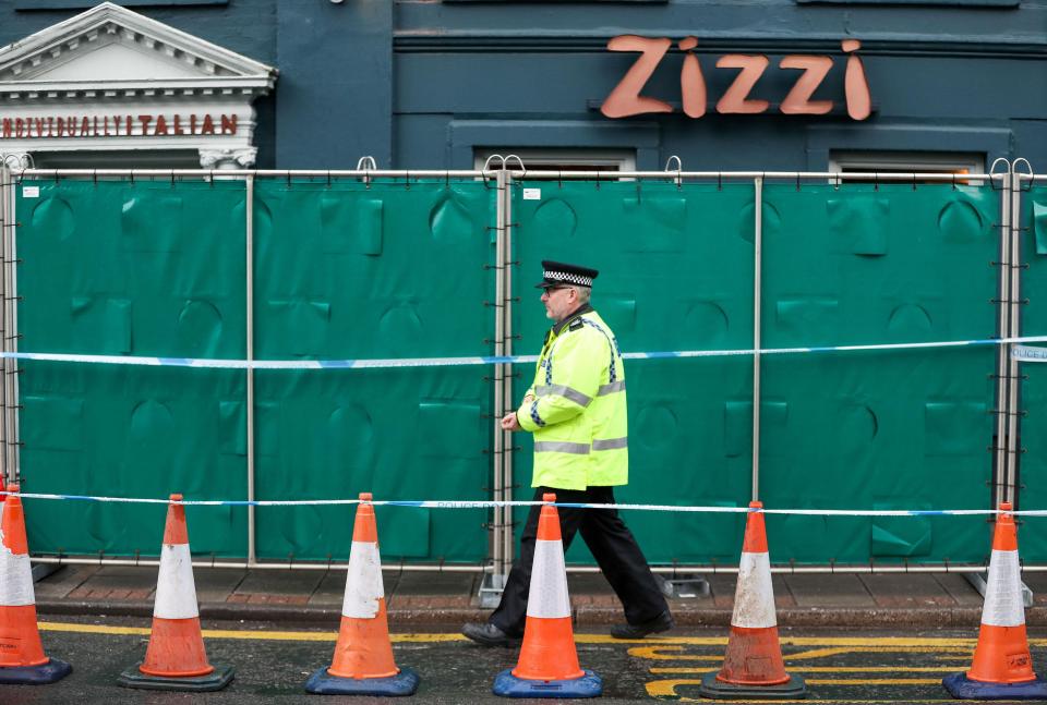  An officer passes a barrier erected by police outside the Zizzi restaurant in Salisbury near to where former Russian double agent Sergei Skripal was found critically ill