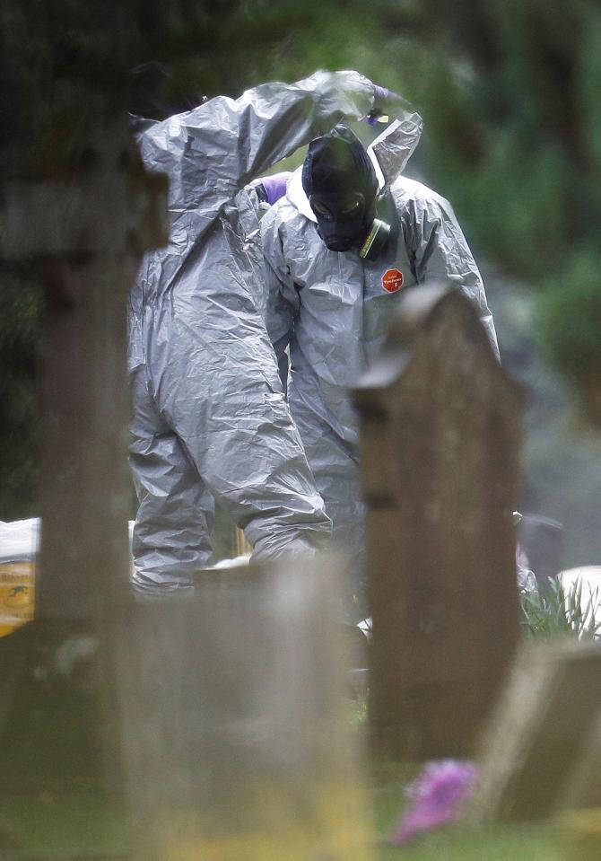  Chemical warfare specialists help each other to remove their protective suits at the site of the grave of Luidmila Skripal