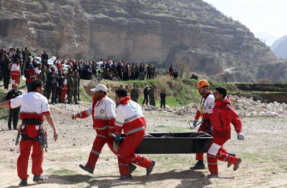  Members Iranian red crescent carry a body recovered from a wreckage of the Turkish private jet