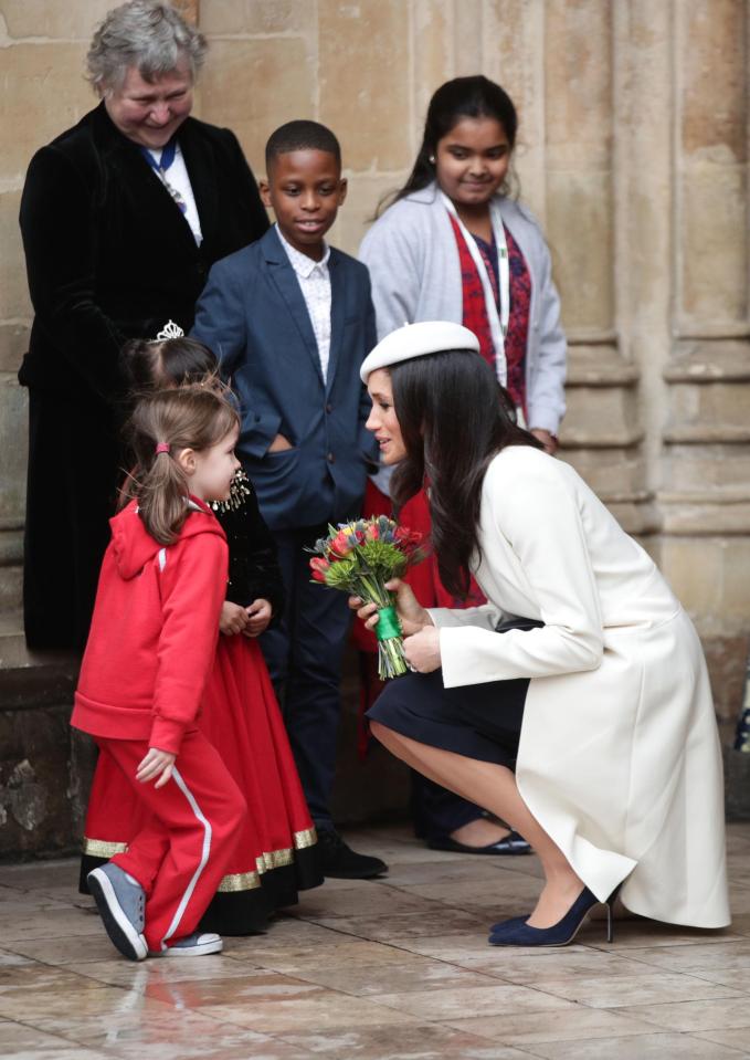  Meghan talks to a child as she leaves the event