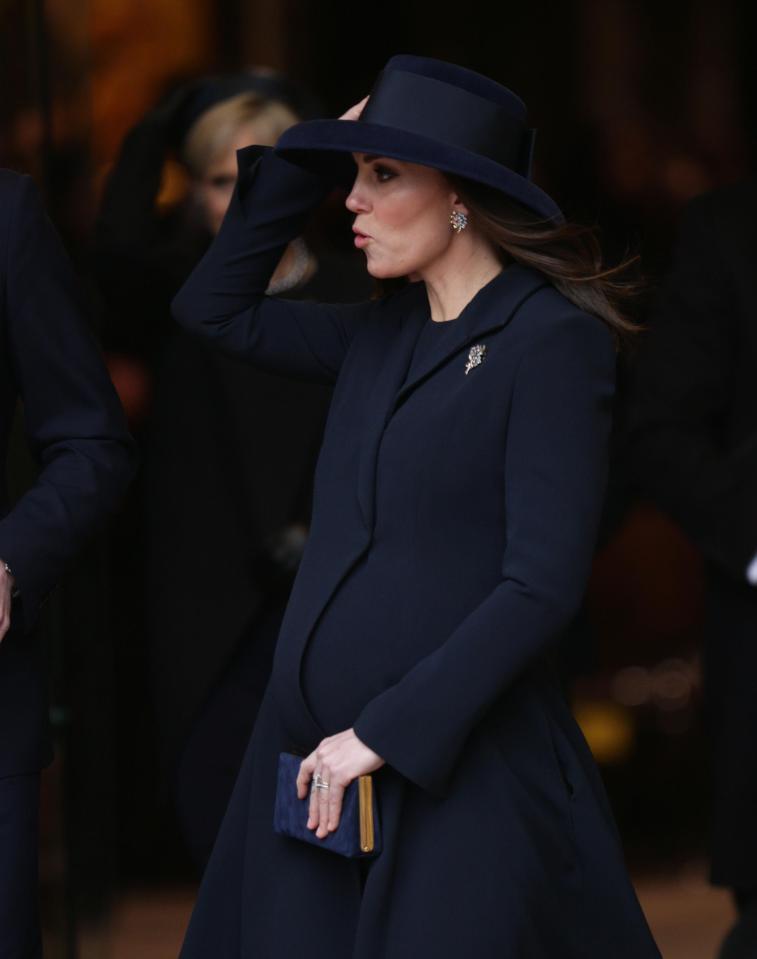  Duchess of Cambridge holds onto her hat as she leaves