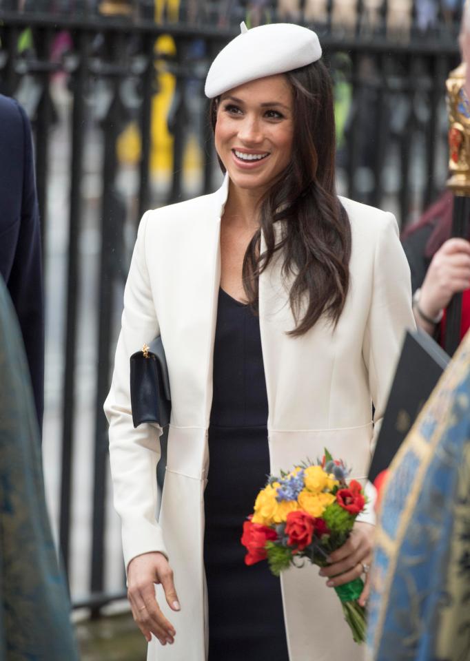  Meghan was seen smiling after the event as she clutched flowers