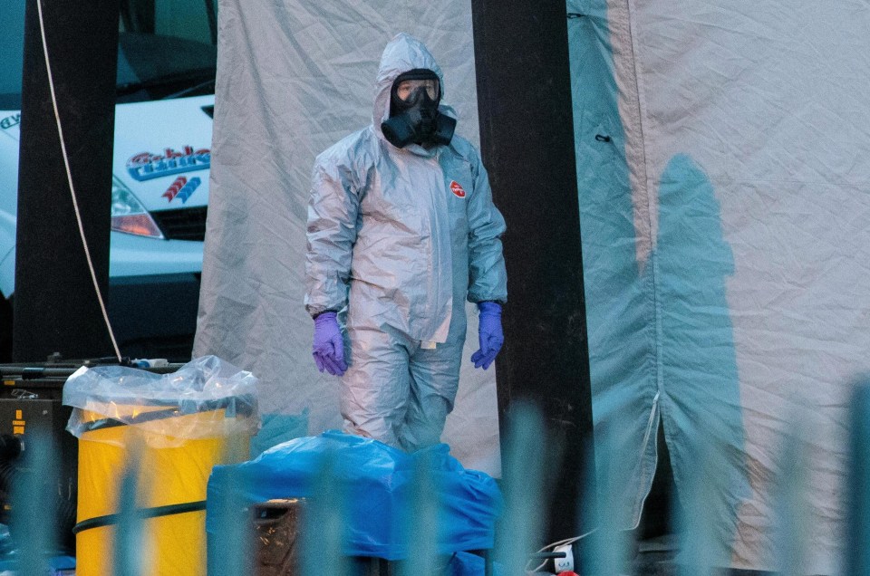 A police officer in a forensics suit and protective mask stands by a forensics tent outside a vehicle recovery centre as investigations continue into the poisoning of Sergei Skripal