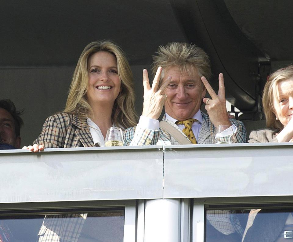  Rocker Rod signalling with three fingers up and two on the other hand as wife Penny watches on entertained