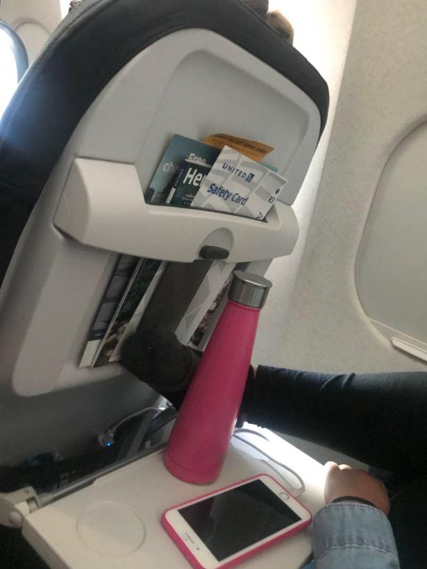  Frederick tweeted a photo of the woman next to him on board a United Airlines flight - who had her foot on the tray table