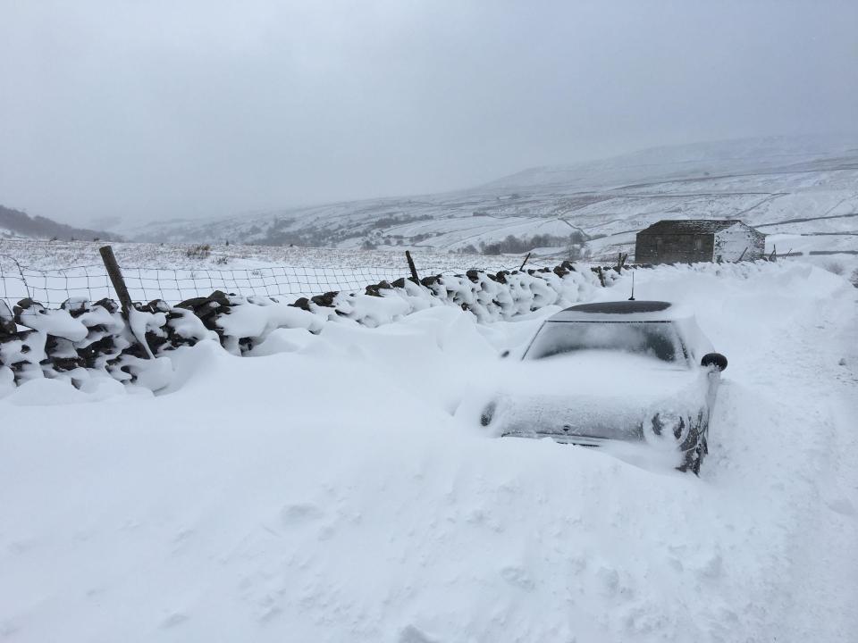  A car is left abandoned in a snow drift in Thwaite, North Yorkshire