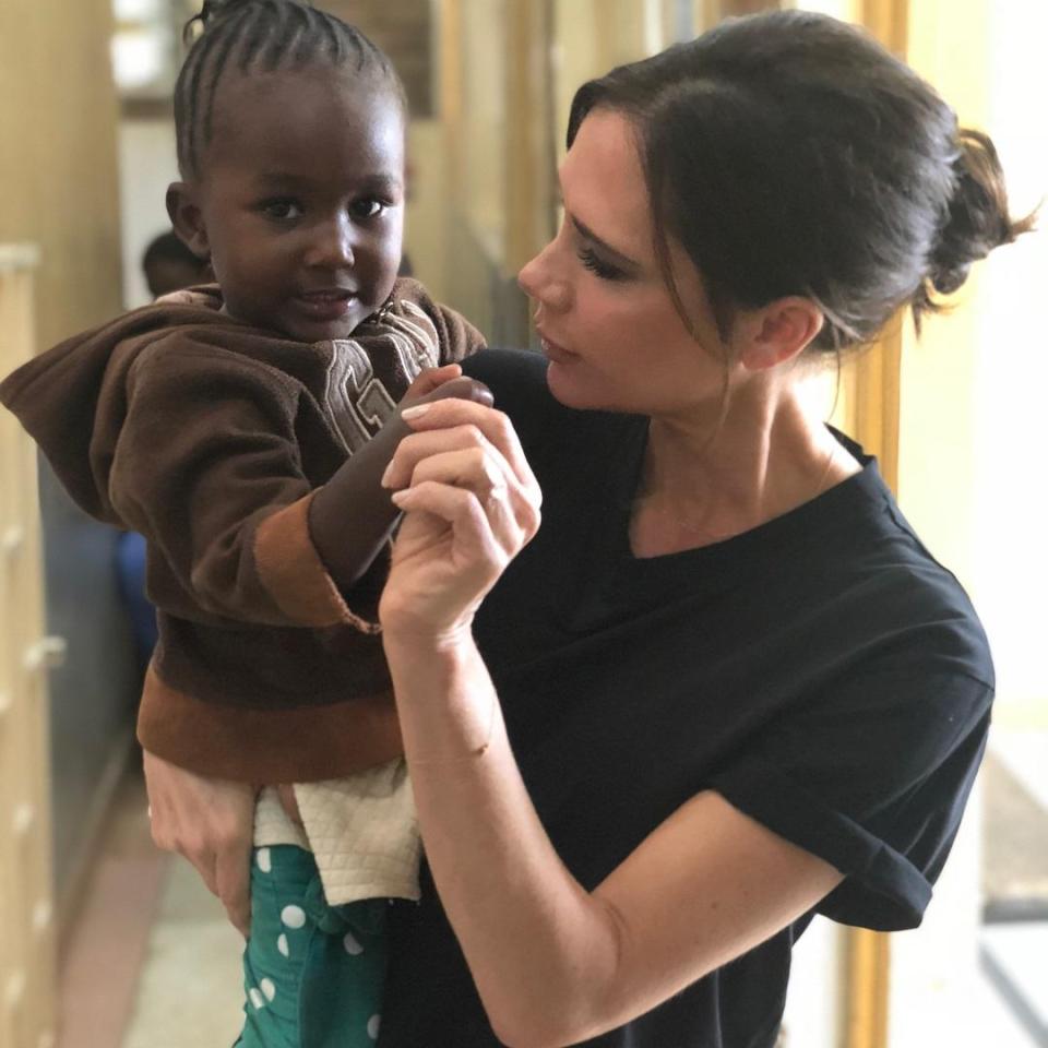  Posh spice with a young girl while visit community projects last weekends