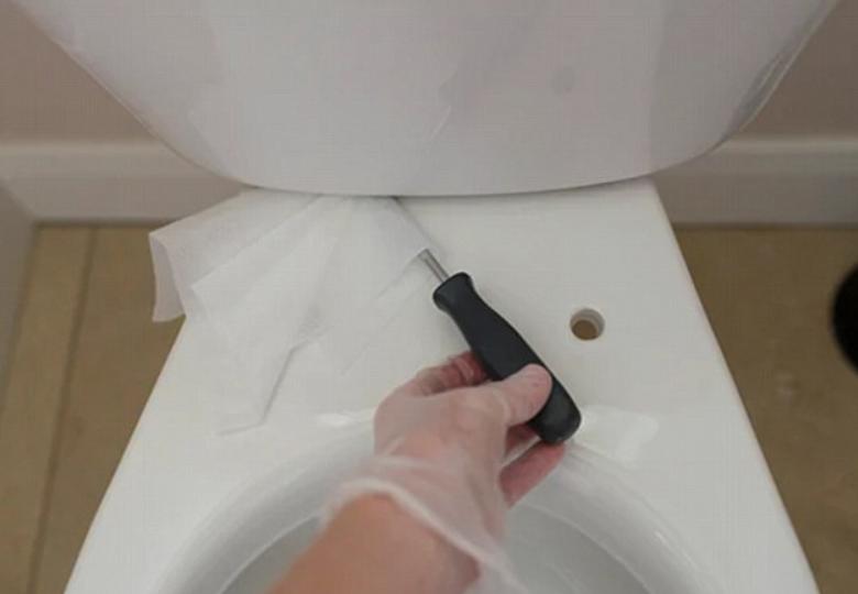  A wet wipe placed over a screwdriver will help you get into the gap under the toilet tank