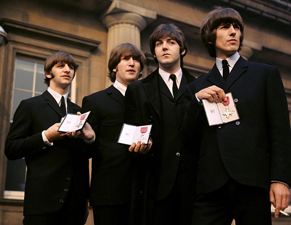 Ringo Starr, John Lennon, Paul McCartney and George Harrison of The Beatles holding their MBEs in 1965