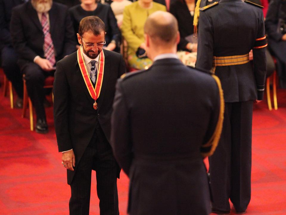 The 77-year-old bows his head as waits to be knighted at an Investiture ceremony at Buckingham Palace