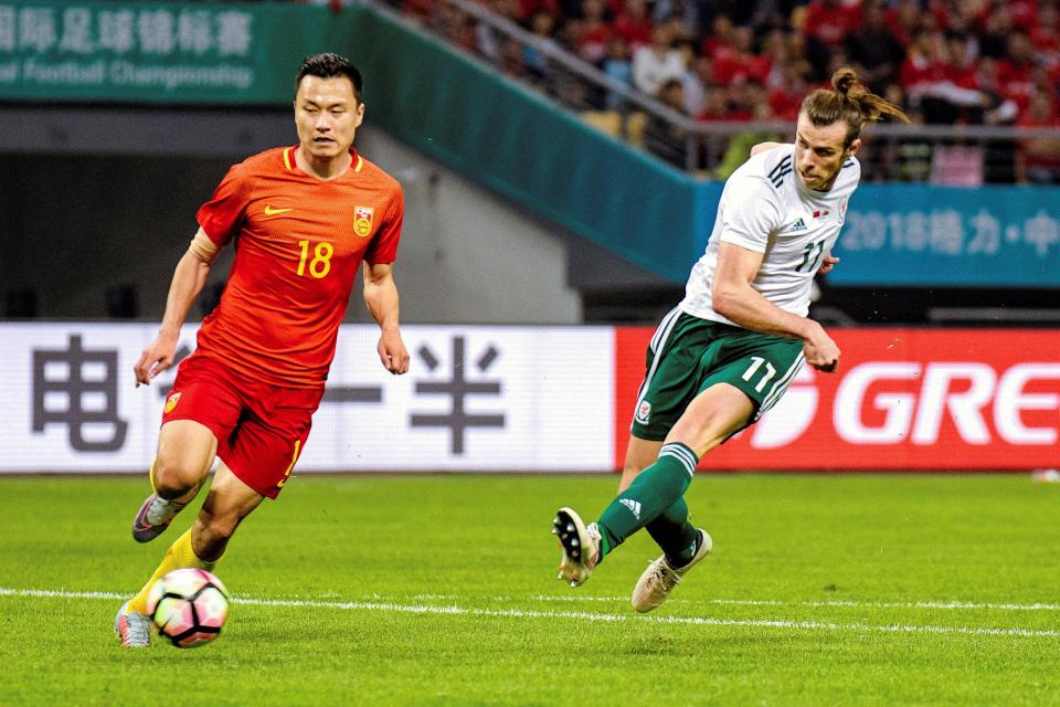 As Gareth Bale scores, he fires past Gao Lin, whose arm is covered by patch