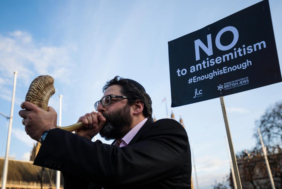  A protester blows through a shofar during the demonstration in Parliament Square