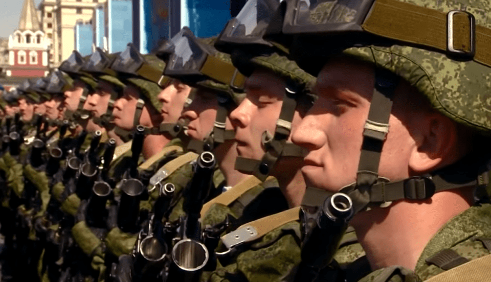  Russian solders are shown standing to attention while Putin claims a 'powerful bloc mentality' could jeopardise world peace