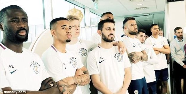 Manchester City players listen to the speech from manager Pep Guardiola, who has won his first Premier League title