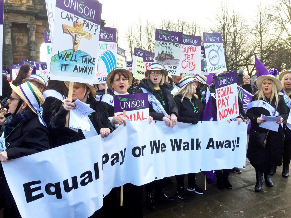  Hundreds of women, some dressed as suffragettes, campaigning for equal pay