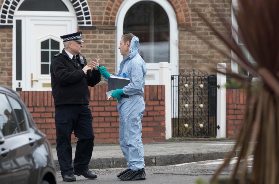  A forensic officer speaks to a police officer outside the property