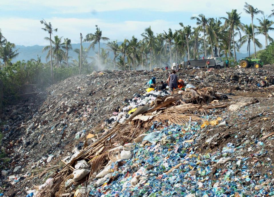  The island was closed in April after the president of Philippines likened it to a 'cesspool'. Pictured, scavengers sift through piles of garbage