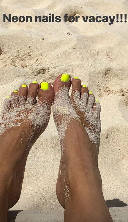  Kim also showed off her neon nails as she relaxed on the beach