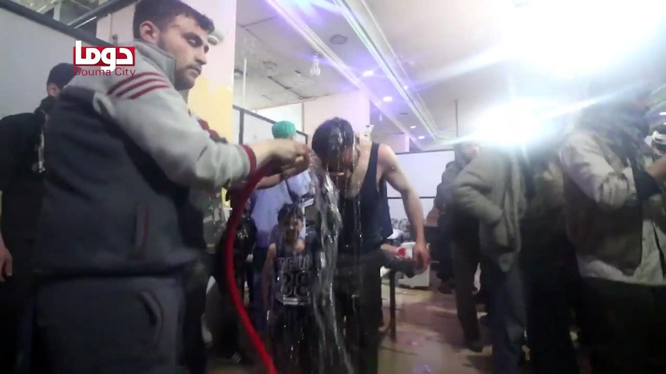 Volunteers spraying a man with water at a make-shift hospital following an alleged chemical attack on the rebel-held town of Douma