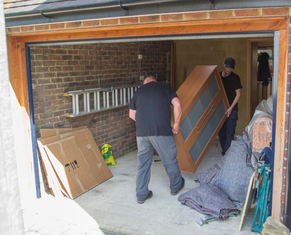  Two men carry furniture out of the Osborn-Brooks' home in Hither Green, South East London today