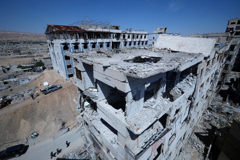 People gather in front of a hospital that locals referred as Point One, just metres away from where the alleged chemical weapons attack occurred in the town of Douma