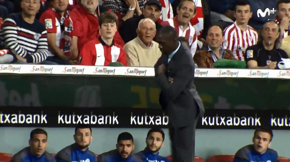  Clarence Seedorf traps the ball while wearing a suit and trainers with his arms crossed