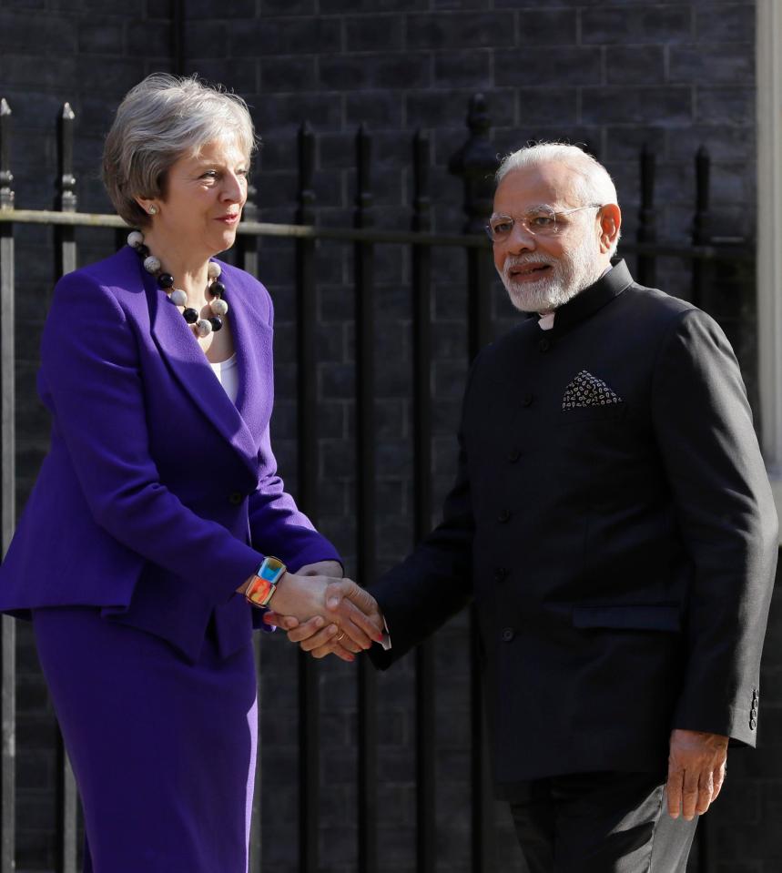  Indian Prime Minister Narendra Modi smiles with Theresa May after he was greeted in London by hundreds of protesters condemning the country's rape crisis