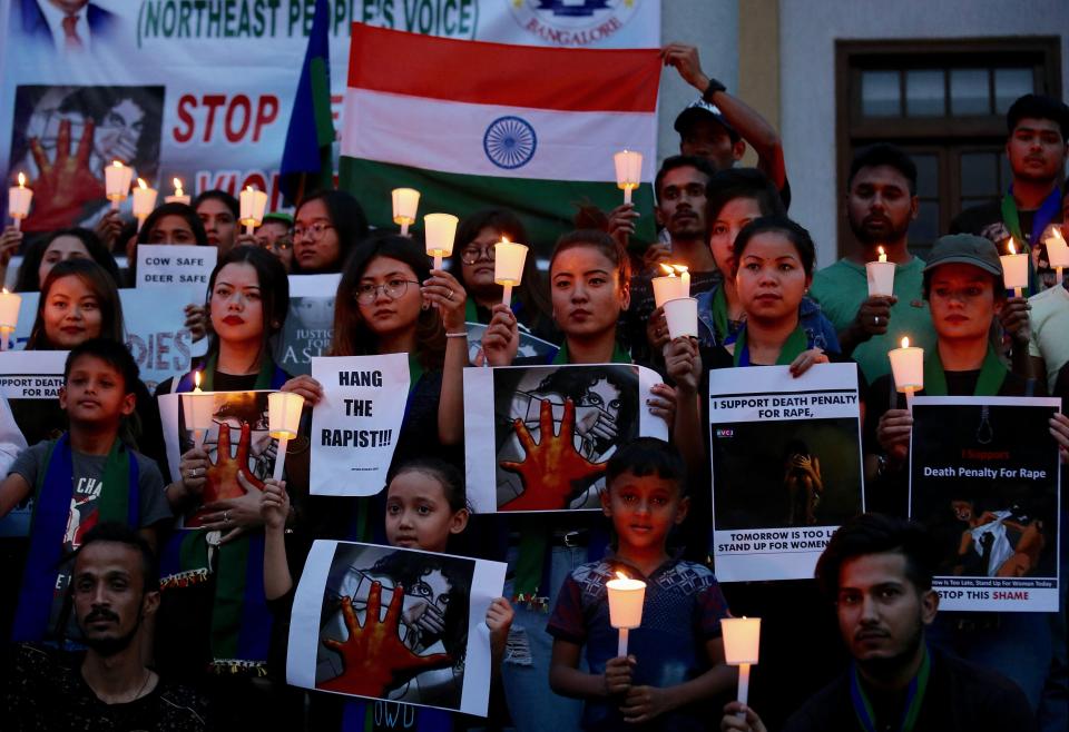  Members of the Northeast People Voice India Foundation hold a candle light vigil paying tribute to the eight-year-old who died