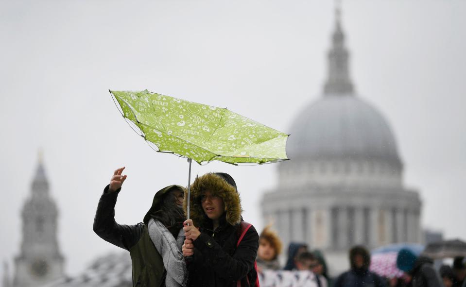  Tourists near St Paul's have been fighting the unfavourable weather