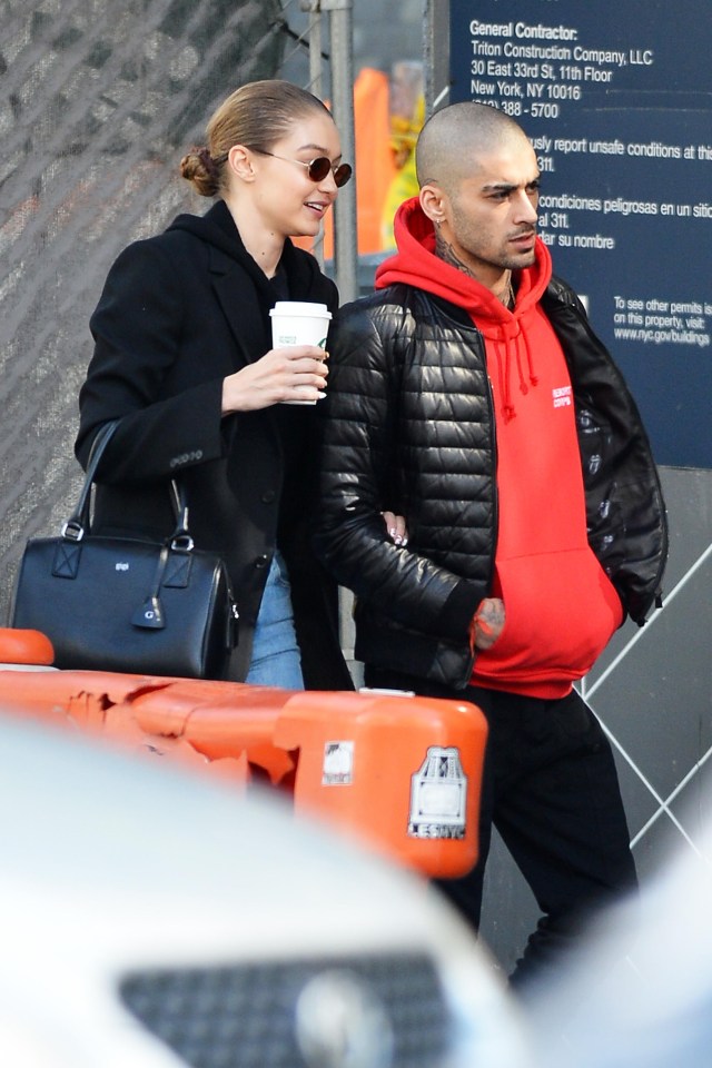 Zayn wrapped up in a red hooded jumper and black coat