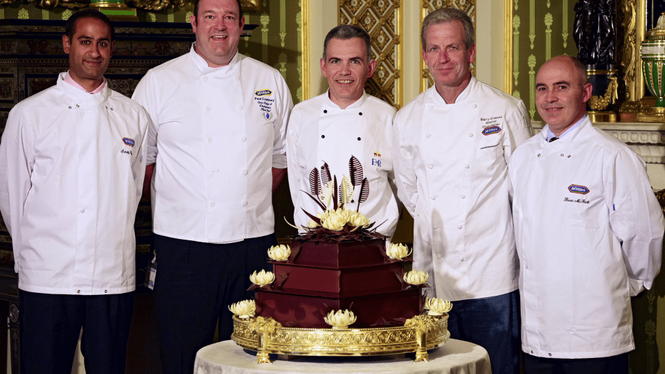 The team pose proudly with the cake nearly ruined by Harry