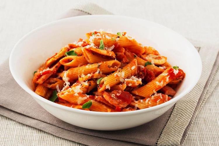 a white bowl filled with pasta and tomato sauce