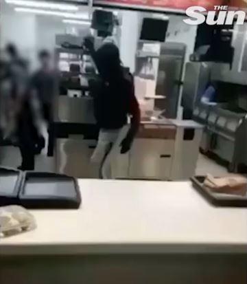  While it's unclear when it was filmed, the shameless thief jumps the counter with his hood pulled up and grabs the roll - just feet away from McDonald's staff