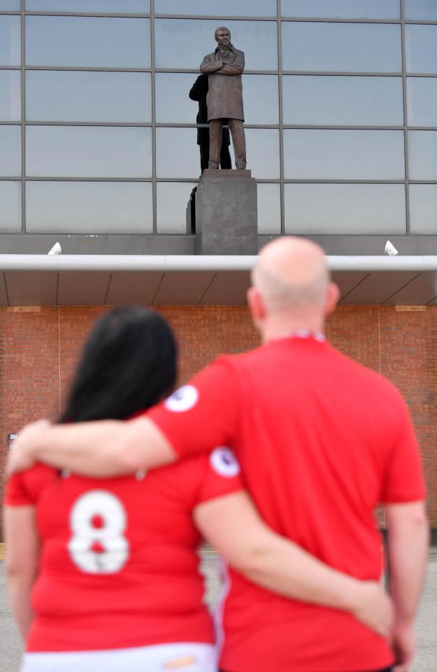  Fergie fans paying homage to the Man Utd legend at his Old Trafford statue