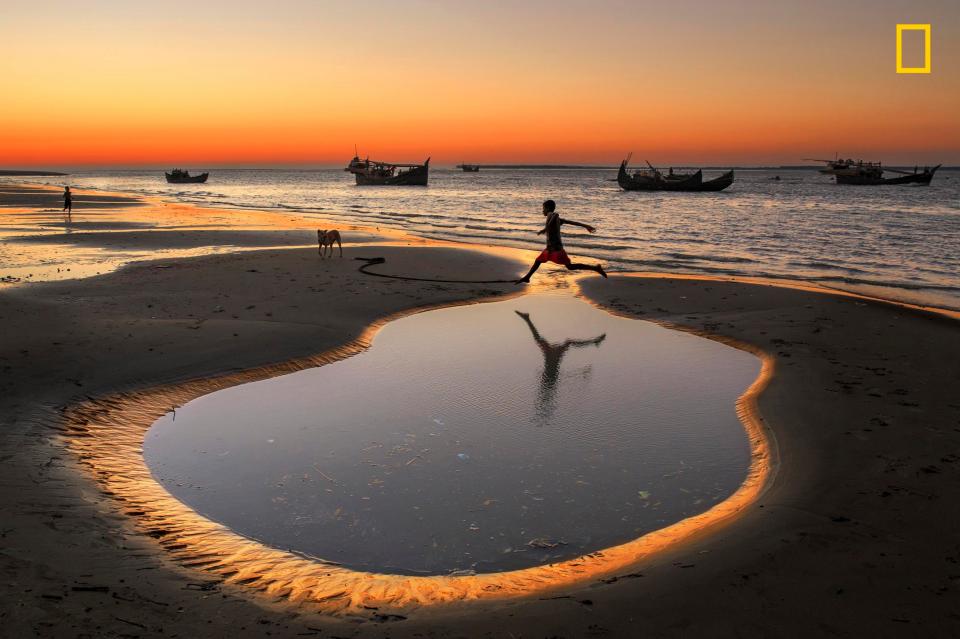  A boy jumps a pond on a beach at Cox’s Bazar Dry fishing village, Bangladesh. More than 5,000 families rely on dry fish processing to survive, while children make their own fun among the dunes, according to photographer Yousuf Tushar