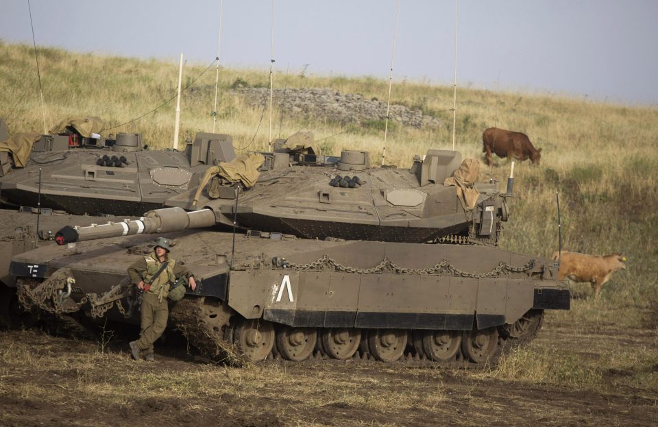  An Israeli Soldier is seen next to Merkava tanks deployed near the Israeli-Syrian border on May 10, 2018 in the Israeli-annexed Golan Heights