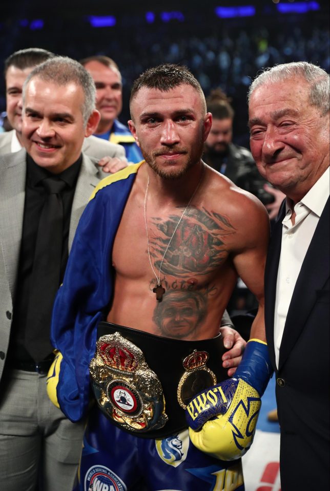 Vasly Lomachenko celebrates after becoming three-weight world champion