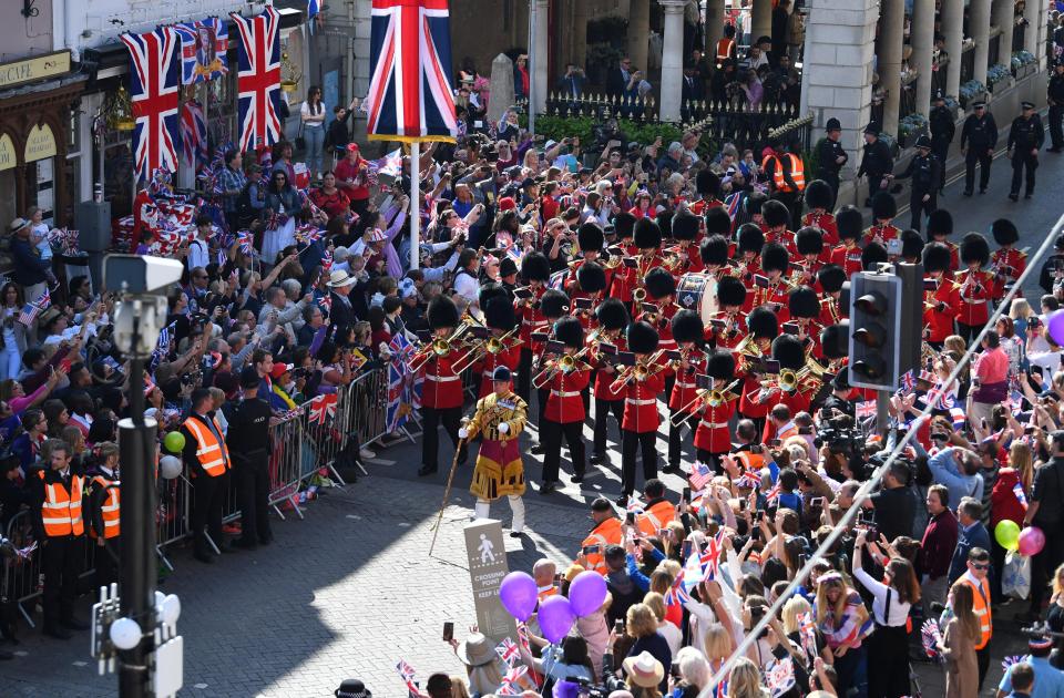  The Queen's Guard band marches through the streets of Windsor as cheering crowds watch on