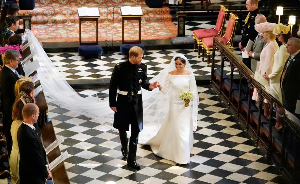  Harry and Meghan hold hands as they walk down the aisle