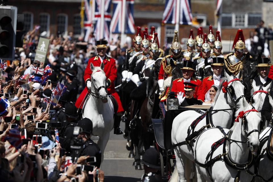  Harry and Meghan beam at the excited crowds, who were all hoping to snap a picture of the couple