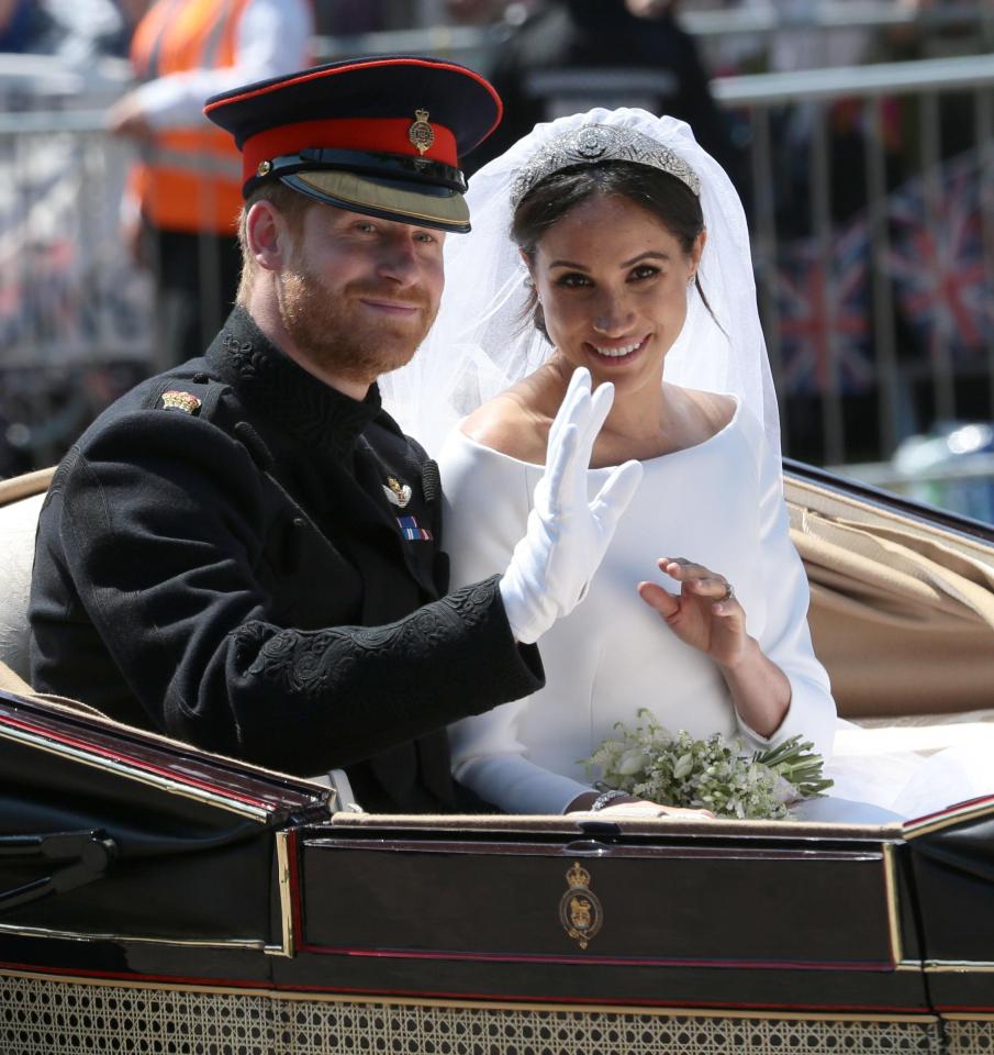 Prince Harry and new bride Meghan ride in an open-topped carriage through Windsor Castle after getting married