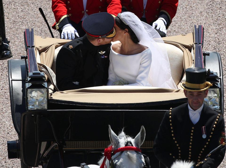  The happy couple share a romantic kiss during their procession through Windsor