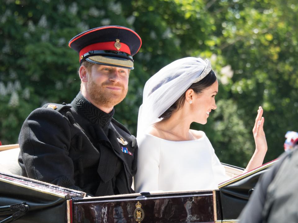  Prince Harry, Duke of Sussex and Meghan, Duchess of Sussex wave from the Ascot Landau carriage during the procession