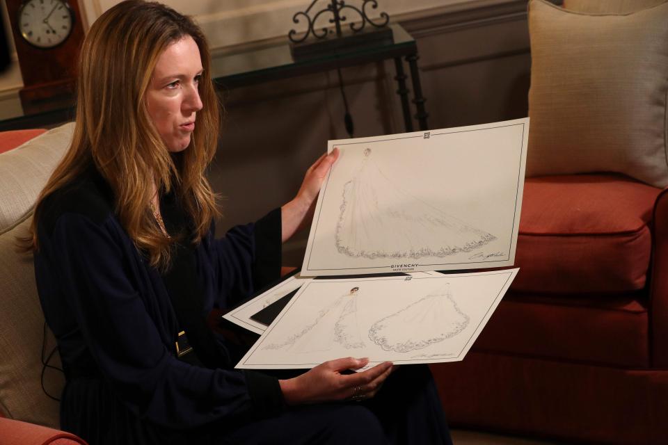  Clare holds dress sketches in Kensington Palace after the Royal Wedding