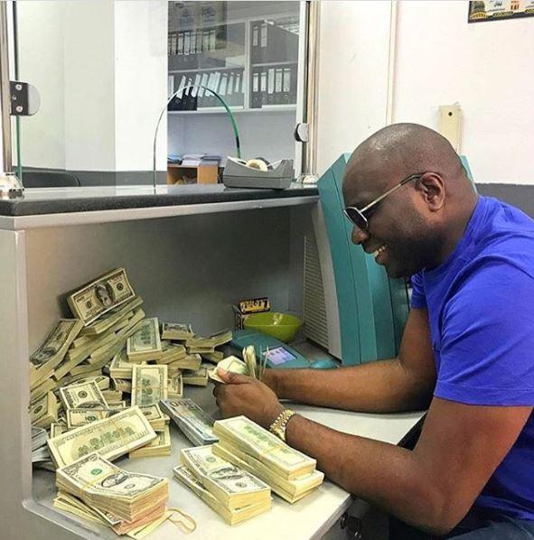  Nigerian businessman Ismaila Mustapha casually counts out bundles of dollars as he encourages others to 'Keep Paving the way!'