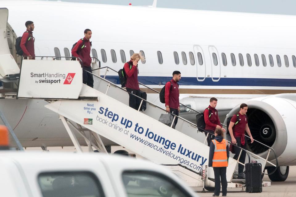 Loris Karius appeared to cover his face as he stepped of the plane at John Lennon Airport