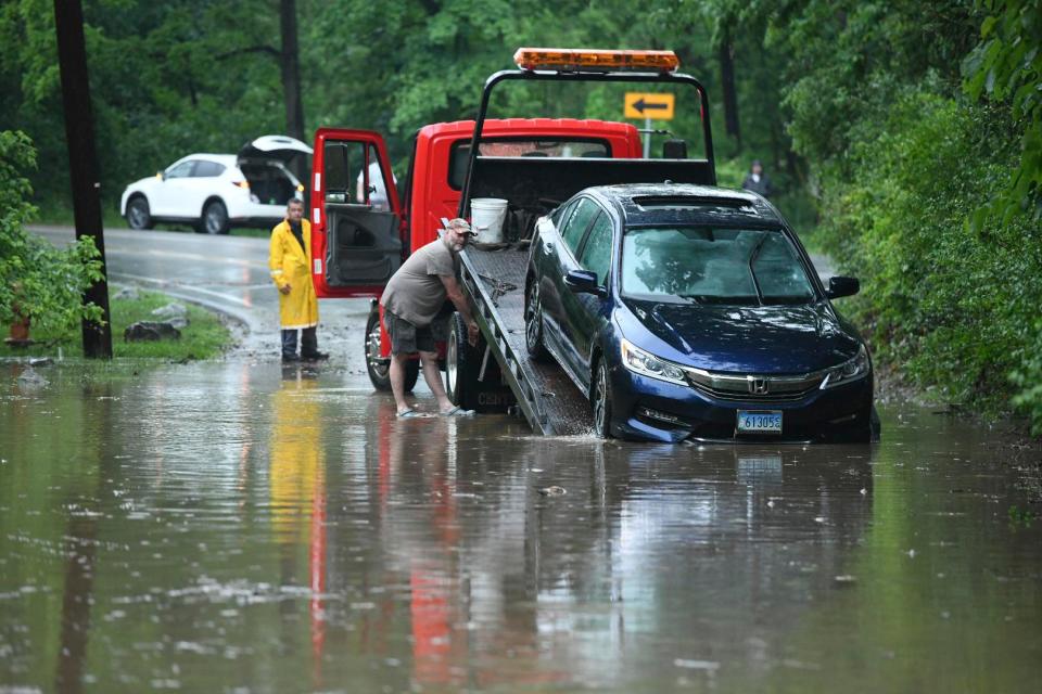  A car is towed after the flood waters recede