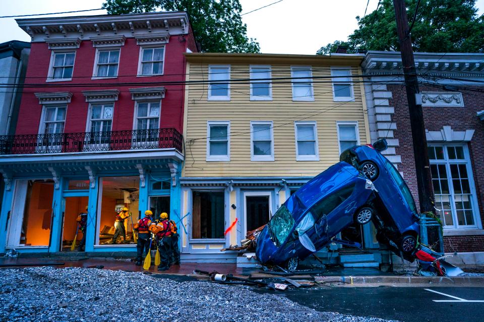  Two cars remain mangled together after the flash floods recede